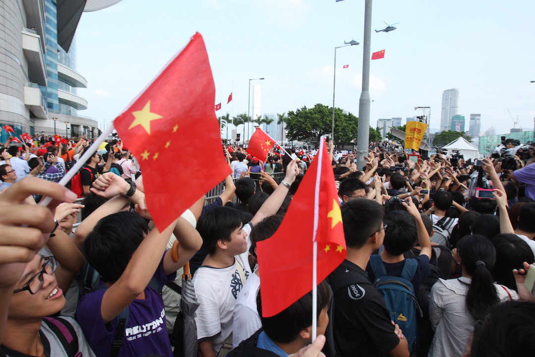 Young protesters wave a reversed Chinese national flag during a flag-raising ceremony where Hong Kong's embattled leader attended in Hong Kong, Wednesday, Oct. 1, 2014, to mark China's National Day. Leung attended the flag-raising ceremony Wednesday to mark China's National Day after refusing to meet pro-democracy demonstrators despite their threats to expand the street protests that have posed the stiffest challenge to Beijing's authority since China took control of the former British colony in 1997. The Chinese words read Step Down. (EyePress/Sunny Mok)